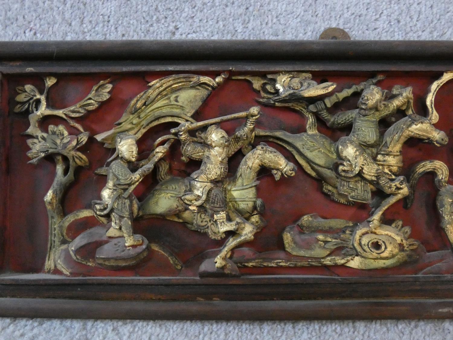 An antique Chinese carved lacquered and gilded panel with red round and warriors on horseback - Image 2 of 7