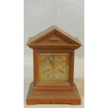 A late 19th century oak mantel clock in architectural case with brass dial on stepped base. H.38 W.