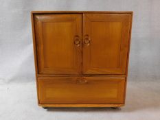 A vintage elm Ercol cabinet with panel doors and drop down base door fitted for HI Fi. H.94xW.85xL.