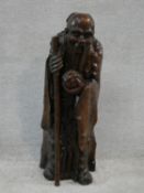 A Ming dynasty carved Chinese root wood sculpture of an immortal, an elderly man holding a staff and