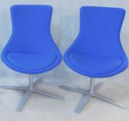 A pair of Orangebox swivel tub chairs in a textile upholstery fitted with seat cushion on metal