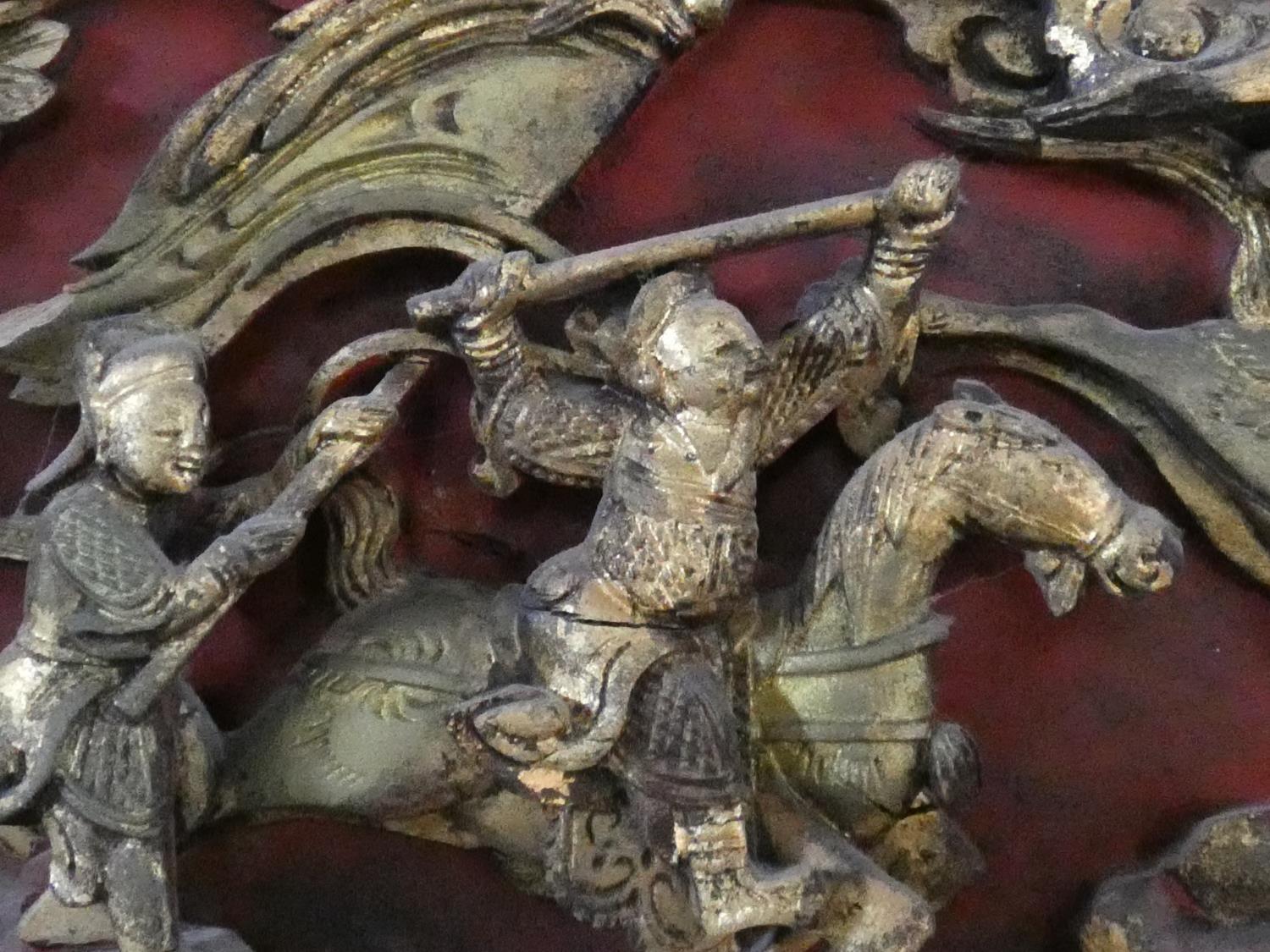 An antique Chinese carved lacquered and gilded panel with red round and warriors on horseback - Image 4 of 7