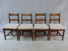 A set of four early 19th century mahogany dining chairs with carved backs and panel seats, fitted