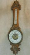 A late 19th century carved oak aneroid barometer with mercury thermometer. 90x25cm