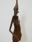 A 20th century South East Asian carved wooden statue of the woman in draping robes and standing on a