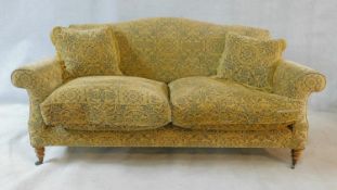 A Georgian style Beaumont and Fletcher sofa in pale gold and sage scrolling floral upholstery raised