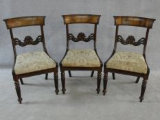 A set of three William IV mahogany dining chairs with figured veneer backrails and acanthus palmette