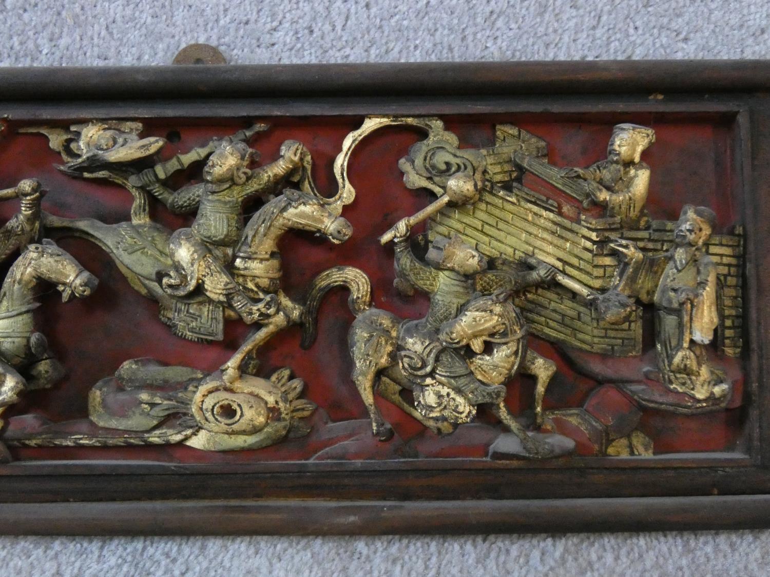 An antique Chinese carved lacquered and gilded panel with red round and warriors on horseback - Image 3 of 7