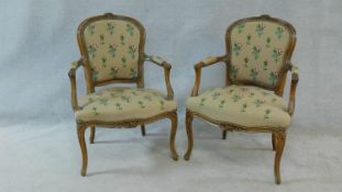 A pair of carved frame Louis XV style open armchairs in floral tapestry upholstery. H.86cm