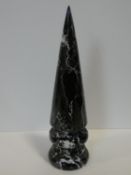 A carved and polished black and white veined marble conical obelisk with grooved base. H.41cm