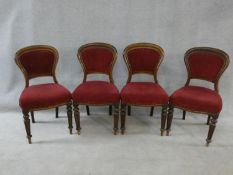 A set of four Victorian mahogany hooped back dining chairs in burgundy velour upholstery on reeded