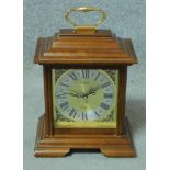 A Georgian style mahogany cased mantel clock with brass carrying handle on stepped bracket feet. H.