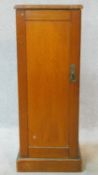 A 19th century pine pot cupboard with painted faux grained panel door enclosing shelves on plinth