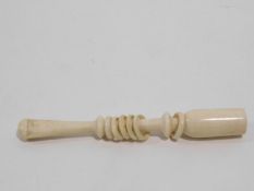 A antique carved ivory cheroot holder with six movable rings that make a noise when shaken. W.10cm