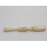 A antique carved ivory cheroot holder with six movable rings that make a noise when shaken. W.10cm