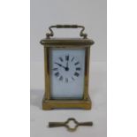 A French antique brass carriage clock with white enamel dial and black Roman numerals. Movement