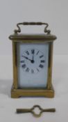 A French antique brass carriage clock with white enamel dial and black Roman numerals. Movement
