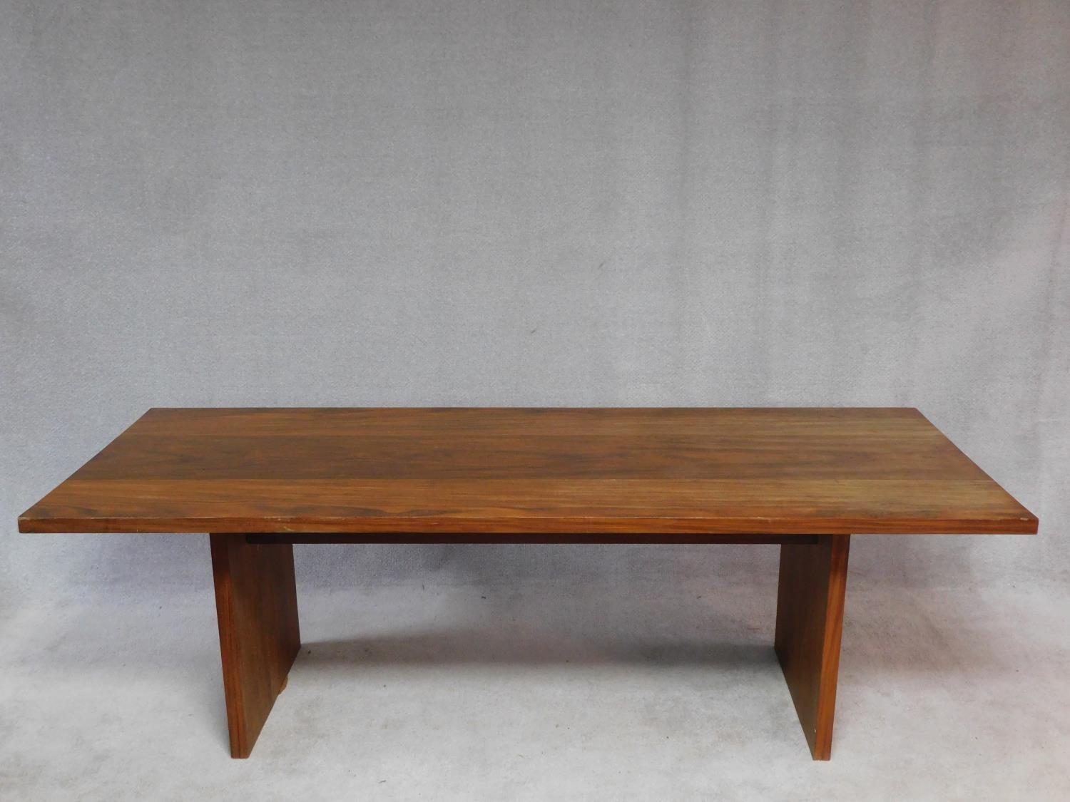 An African hardwood refectory type table with heavy planked top on block trestle supports. H.70 W.