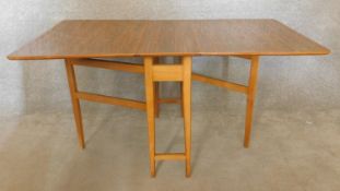 A vintage teak drop flap dining table with gateleg action. H.73 W.149 D.84cm