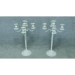 A pair of white painted metal five branch table candelabras. H.78cm