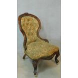 A Victorian carved walnut framed nursing chair in floral tapestry upholstery on cabriole supports.