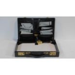 A vintage black leather documents attache case with brass fittings, fitted pocketed interior and