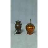 An antique twin handled copper samovar with glass finial and pierced legs along with a ceramic