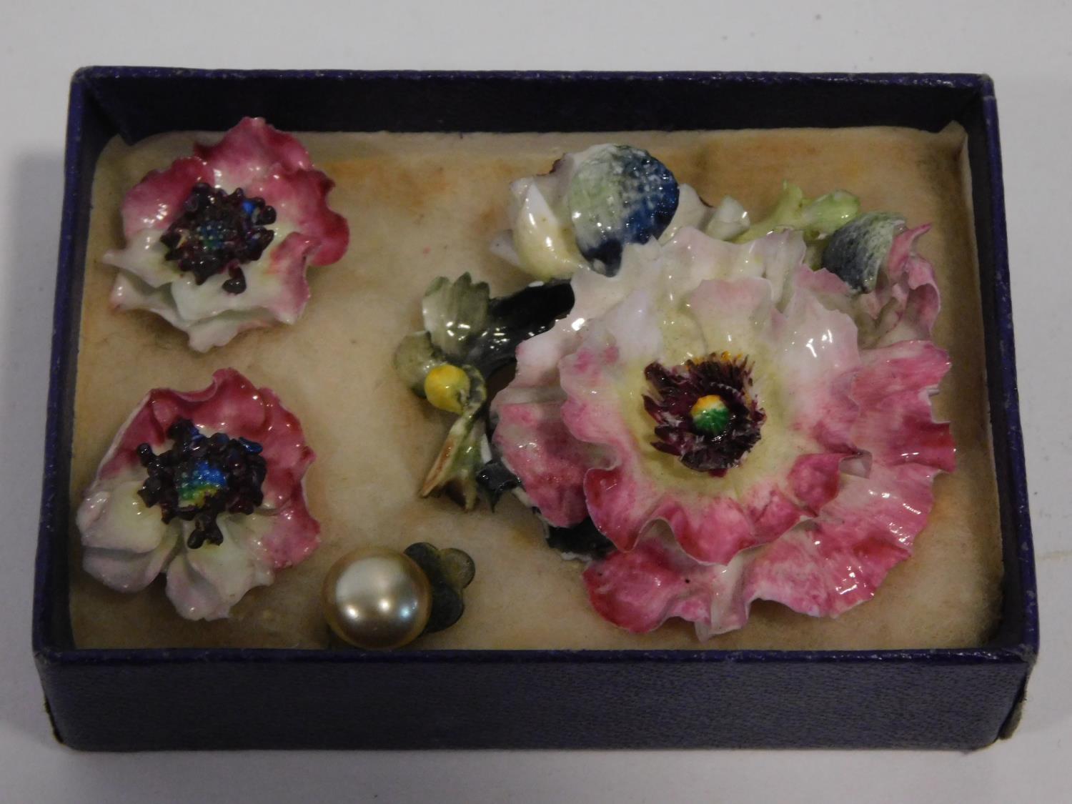 A Royal Crown Derby hand painted porcelain flower brooch and earring suite. Earrings have clip