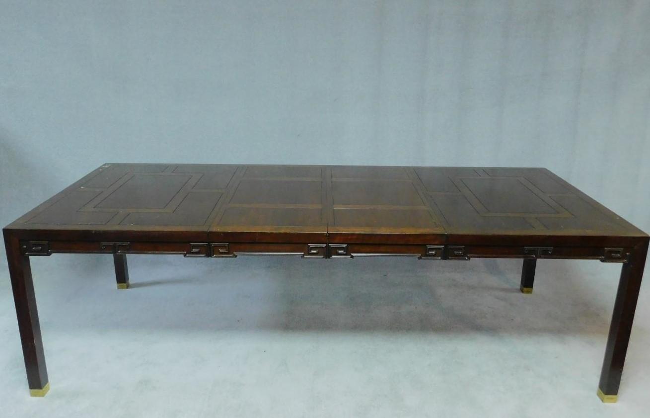 A Chinese hardwood extending dining table with parquetry top above carved frieze on square