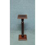 A small 20th century mahogany jardiniere stand with reeded column resting on brass bracket feet. H.