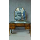 A mid 20th century walnut Queen Anne style dressing table with shaped framed mirror on cabriole