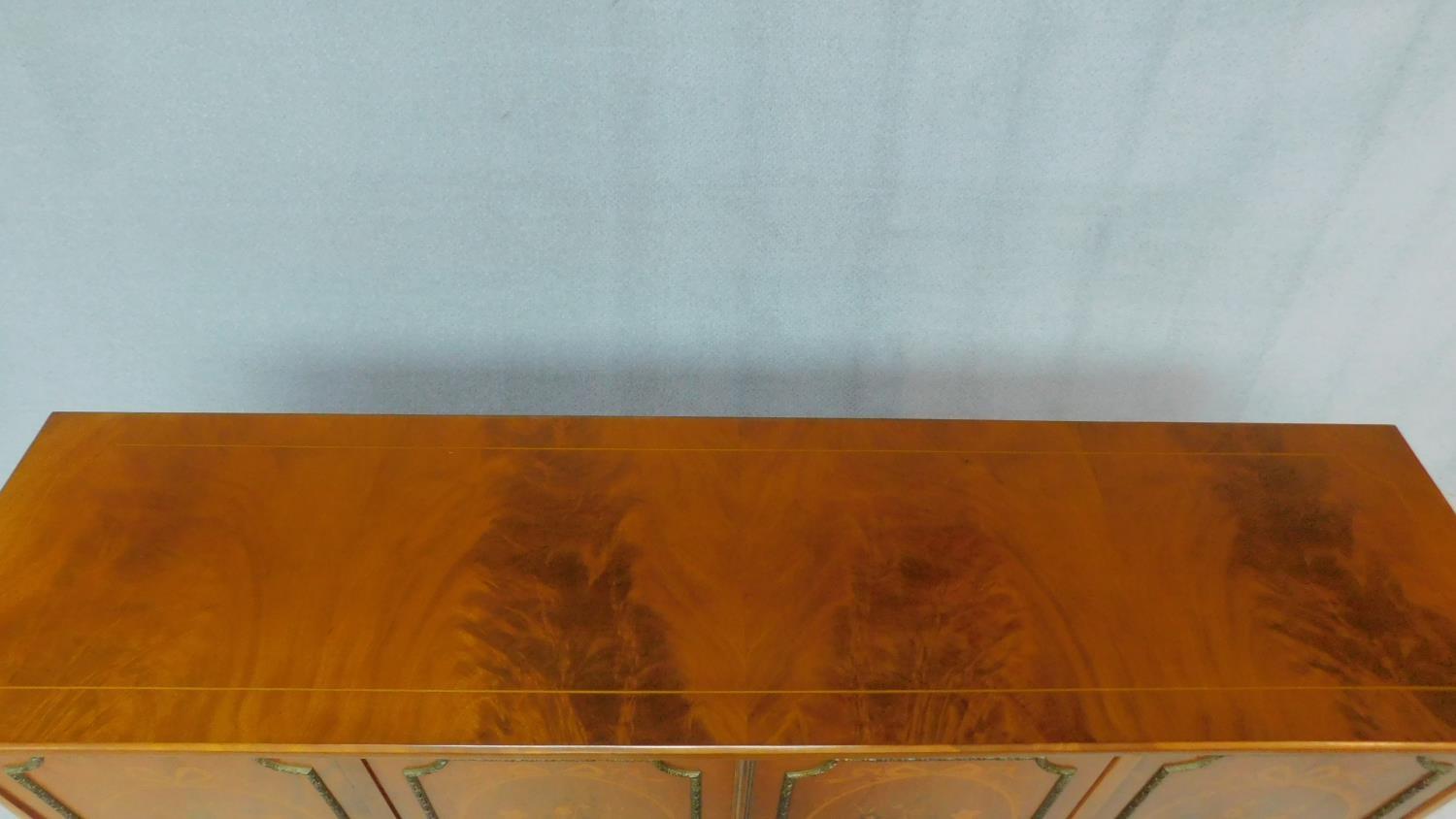 A Continental flame mahogany four door sideboard with floral inlaid panels on fluted tapering - Image 4 of 4