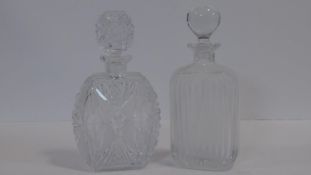 Two crystal decanters one very heavy lead crystal with a geometric and star cut design with matt and