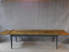 An antique French refectory style dining table with planked and cleated pitch pine top with end