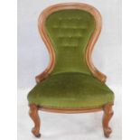 A Victorian mahogany framed spoon backed nursing chair in buttoned upholstery on carved cabriole