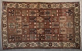 A Persian Bakhtiar carpet with stylised floral panels repeating across the field within stylised