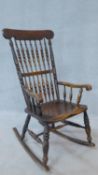 A 19th century beech and elm spindle back rocking chair on turned stretchered supports. H.100cm