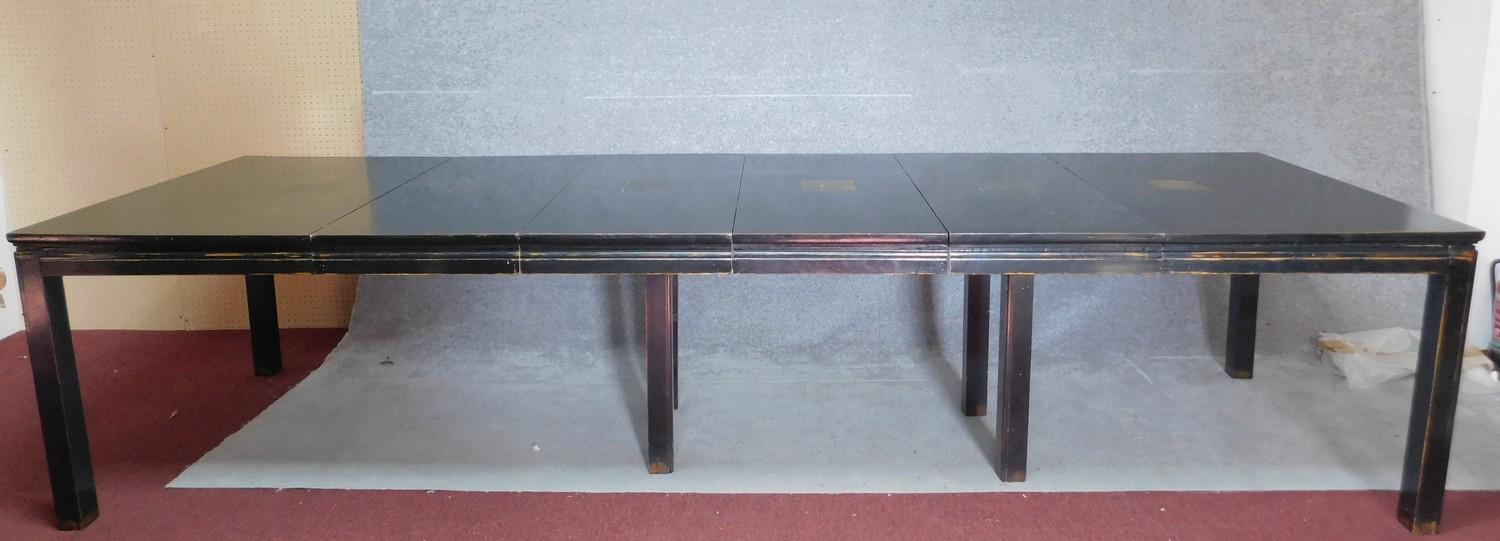 A Chinese ebonised and lacquered extending dining table with four extra leaves on square section
