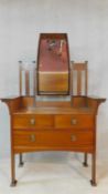 A late 19th century mahogany Arts and Crafts dressing table with carved scrolling foliate and bud