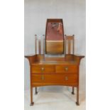 A late 19th century mahogany Arts and Crafts dressing table with carved scrolling foliate and bud