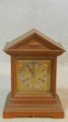 A late 19th century oak mantel clock in architectural case with brass dial on stepped base. H.38 W.