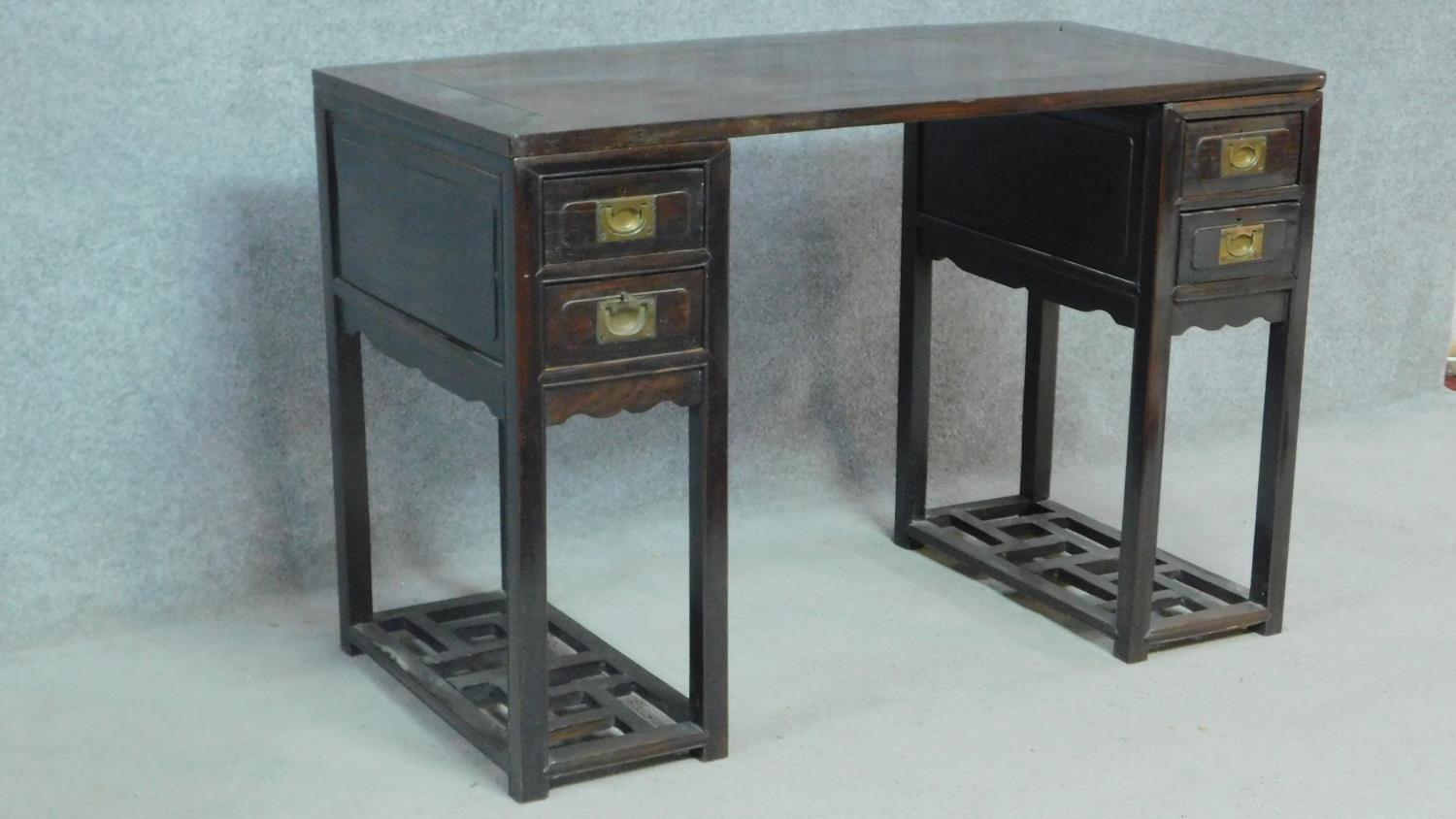 A 19th century Chinese teak three section pedestal desk fitted with two drawers to each side above