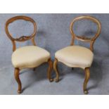 A pair of Victorian walnut balloon back dining chairs in damsk upholstery on cabriole supports. H.