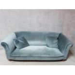 A contemporary two seater tub shaped sofa on turned supports together with a roll of the