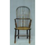 A 19th century elm hooped back Windsor armchair with pierced splat back and saddle seat on turned