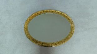 An oval wall mirror in gilt acanthus decorated frame. 70x78cm