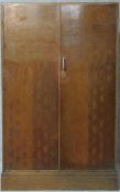 A vintage fitted oak gentleman's wardrobe with slides, drawers and hanging space, patented by