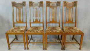 A set of four late 19th century carved oak dining chairs with Glasgow School motif to the back