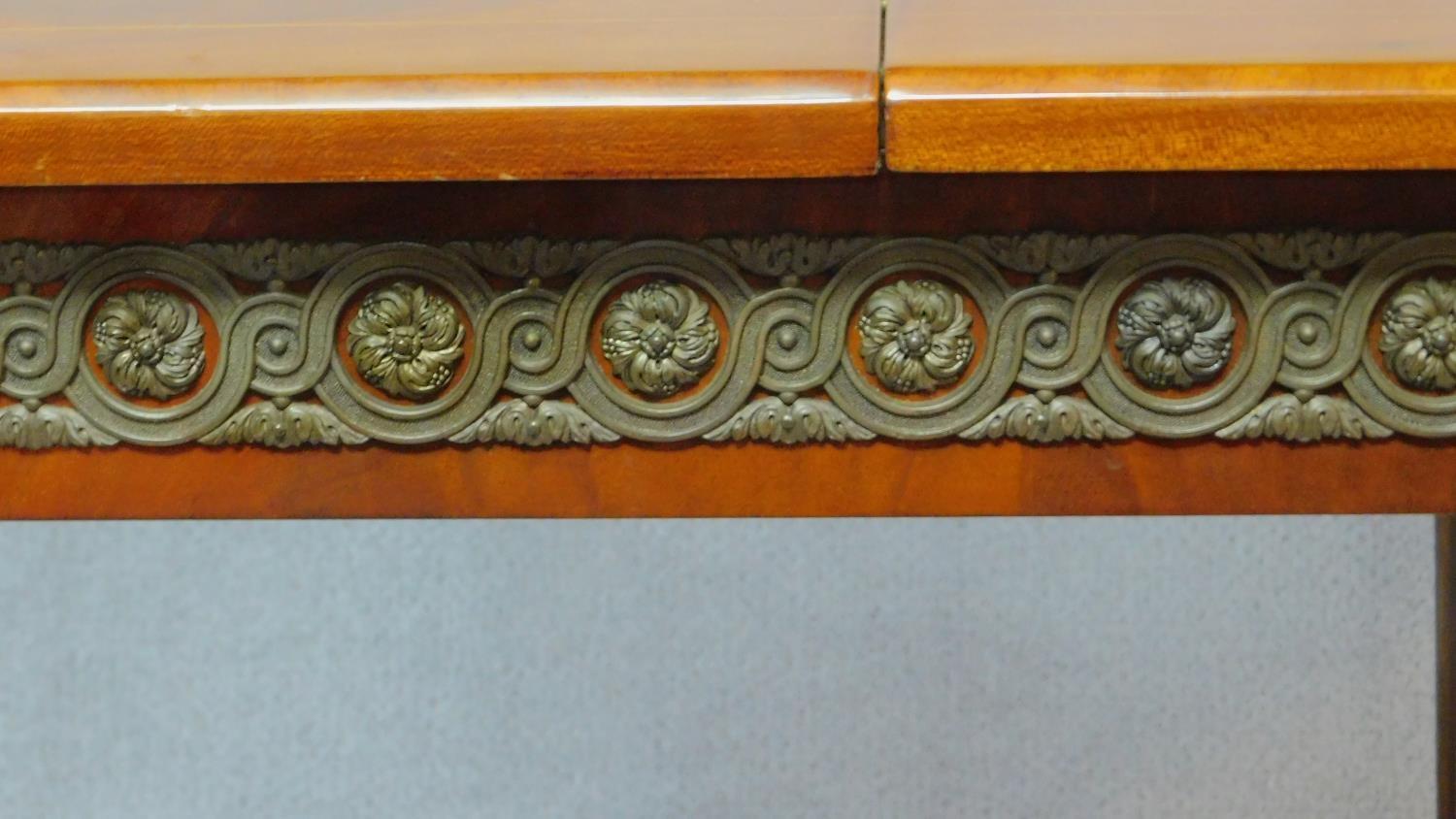 A Continental flame mahogany extending dining table with brass mounts and central floral inlay - Image 4 of 6