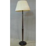 An early 20th century carved and turned mahogany standard lamp on circular base. H.178cm